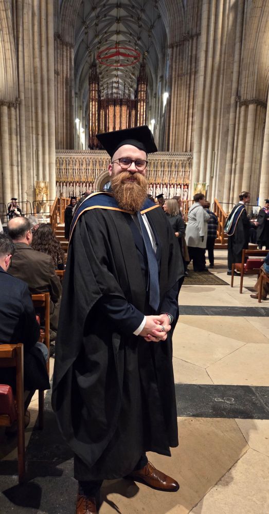 Bearded bloke in academic dress inside York Minster. 