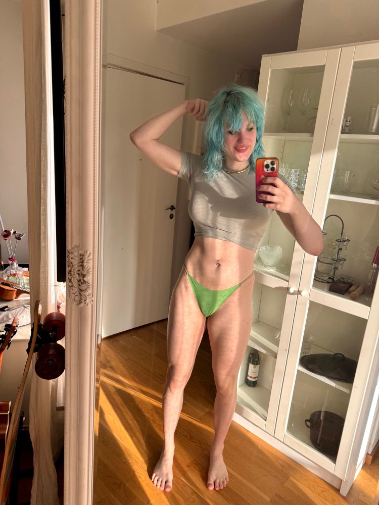 a cute looking girl wearing underwear and a t-shirt she is slender and muscular and she looks a bit goofy with her hair a mess