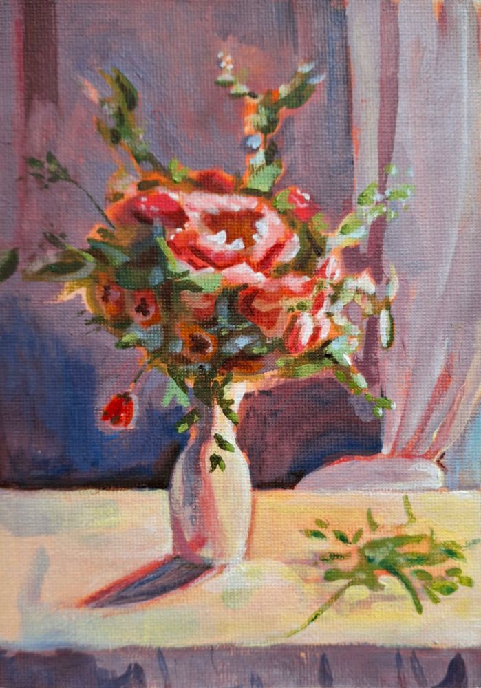 A small acrylic painting depicting a bouquet of pink and red flowers in a white vase, set on a table with a soft, muted background. Warm and cool tones create contrast, with expressive brushstrokes adding texture and movement. A cluster of leaf rests on the table.