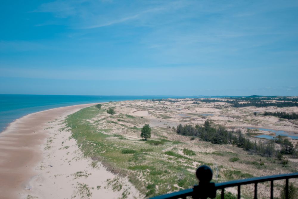 A color photo looking North along the Lake Michigan shoreline, taken from the top of the Big Sable Lighthouse.