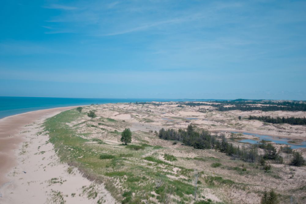 A color photo looking North along the Lake Michigan shoreline, taken from the top of the Big Sable Lighthouse.
