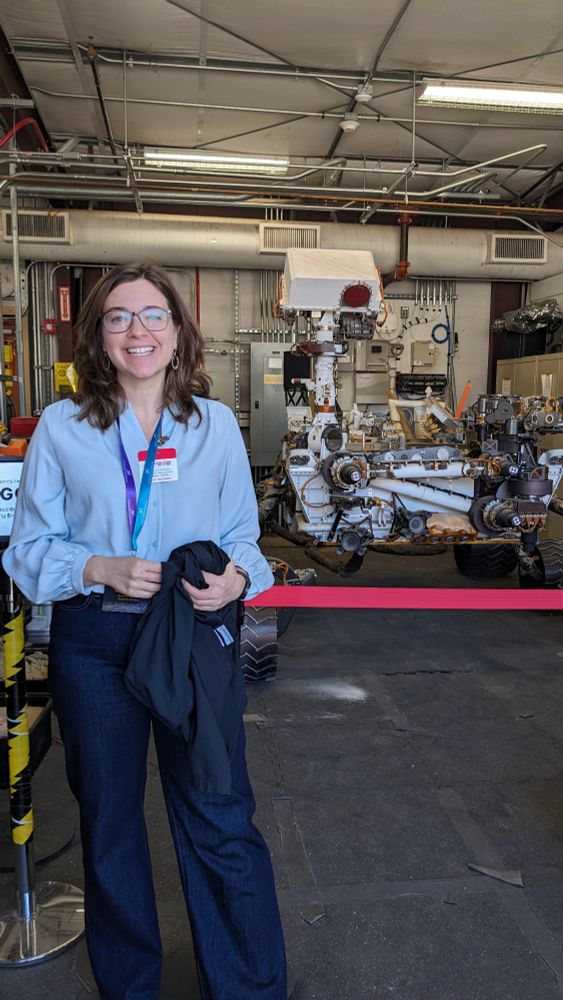 Smiling girl in front of Mars rover in garage