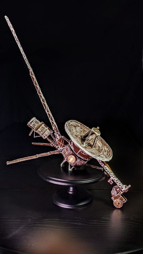 A detailed gingerbread model of a Voyager spacecraft. A tiny golden record gleams on its side.