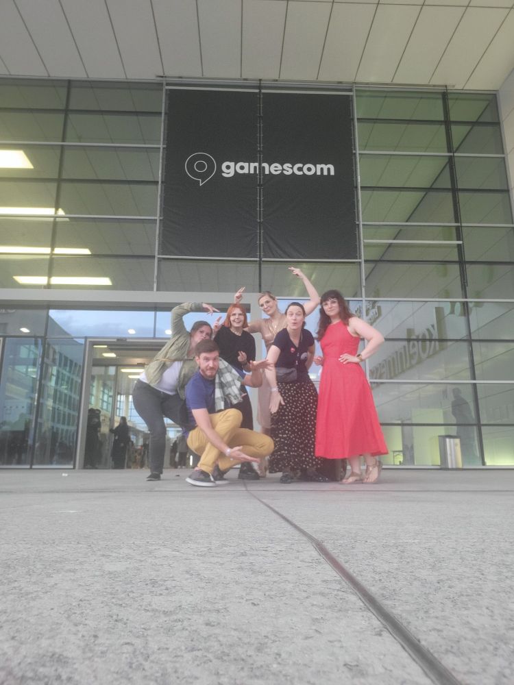 Group of nicely dresses people before a gamescom sign