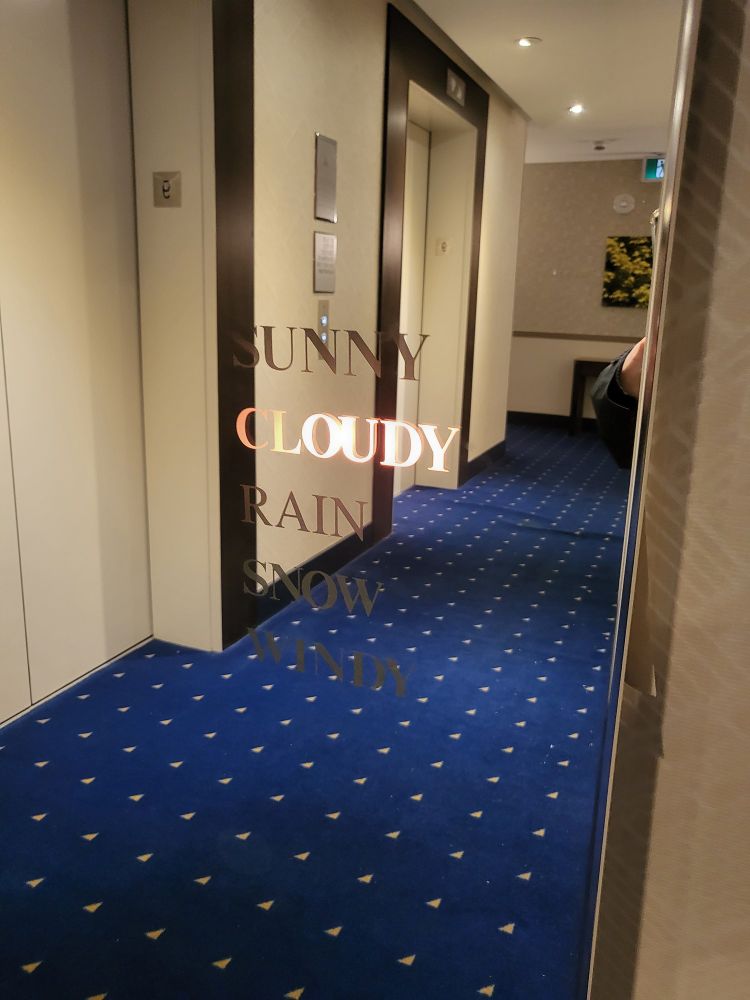 Hotel mirror with glowing Letters reading "cloudy"