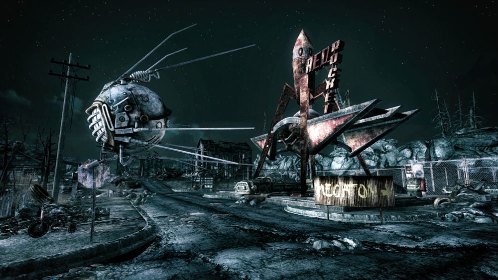 An Enclave eyebot patrols the town of Springvale in the Capital Wasteland in Fallout 3. A Red Rocket glows into the night behind it.