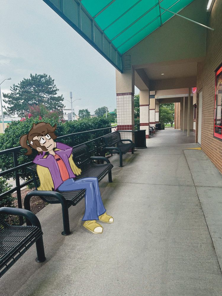 A photo taken of a movie theater. In front of the movie theater is a drawn version of myself sitting down on a bench.