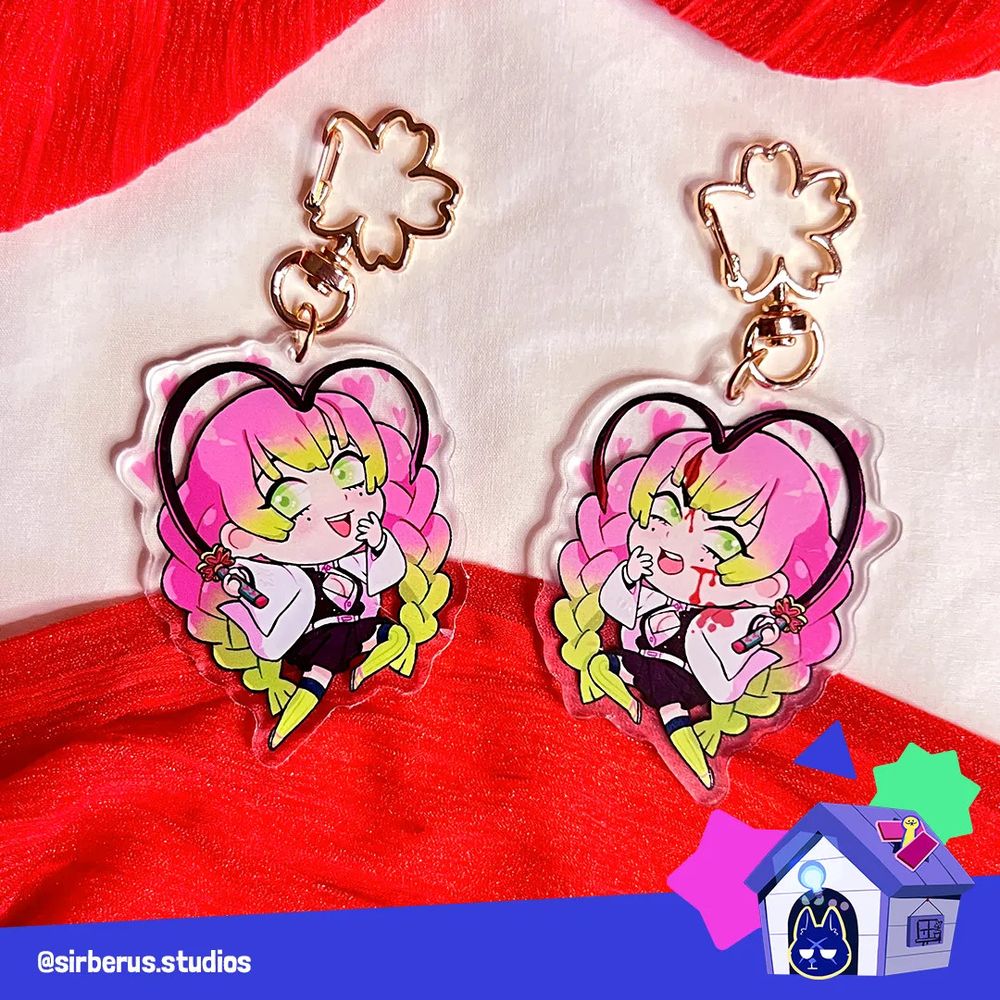 Photo of the Mitsuri acrylic charm showing the two sides, the front side is the default chibi and on the reverse side shows injuries.  The bottom right corner is a graphic indicating the artist is B2. 