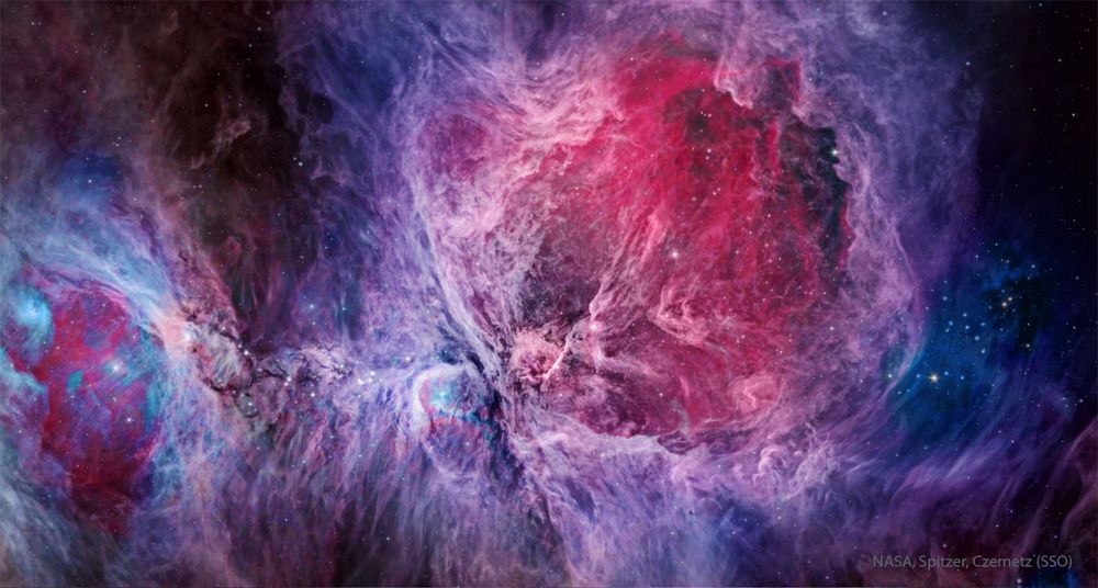A complex nebula fills the frame that is brightly colored, with red being prominent in the image center and blue being most prominent elsewhere. Stars also dot the image. Please see the explanation for more detailed information.