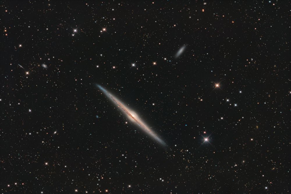 Magnificent spiral galaxy NGC 4565 is viewed edge-on from planet Earth. Also known as the Needle Galaxy for its narrow profile, bright NGC 4565 is a stop on many telescopic tours of the northern sky, in the faint but well-groomed constellation Coma Berenices. This sharp, colorful image reveals the galaxy's boxy, bulging central core cut by obscuring dust lanes that lace NGC 4565's thin galactic plane. NGC 4565 lies around 40 million light-years distant while the spiral galaxy itself spans some 100,000 light-years. That's about the size of our own Milky Way. Easily spotted with small telescopes, deep sky enthusiasts consider NGC 4565 to be a prominent celestial masterpiece Messier missed.
