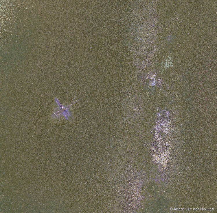 A starscape is shown with the central band of the Milky Way Galaxy running down the center. Just to the left of the Milky Way is a bright meteor. In the three frame time-lapse image, the meteor explodes and gas and dust drift away. Please see the explanation for more detailed information.