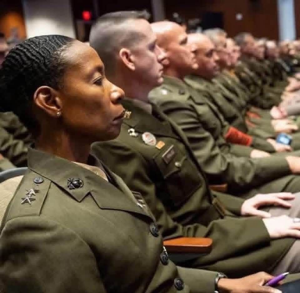 First black female Marine Corps General sitting in the audience to hear the absurd speech of Hegseth and Trump. She, as everyone in this photo, has a very stoic expression on her face. 