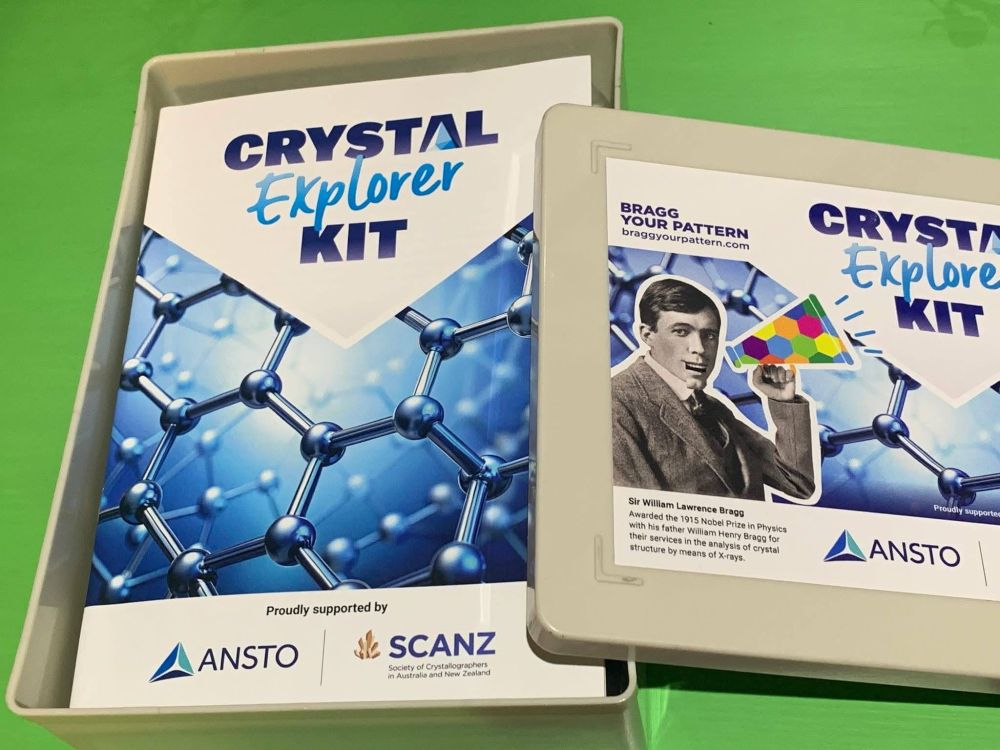 A box that is open with the lid to one side, inside the box is a booklet that is titled 'Crystal explorer Kit' and the lid has a sticker with the same title and an amusing picture of Sir William Lawrence Bragg