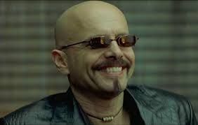 A still image from the movie The Matrix showing the character Cypher. Cypher betrayed Morpheus in exchange for being put back into the Matrix to live in blissful ignorance. 
