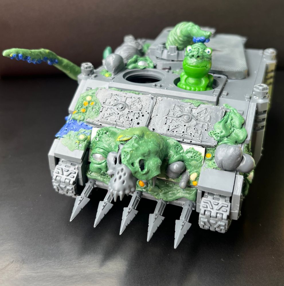 Miniature Rhino tank customized for the Death Guard. Modified with green stuff parts, glass beads and sprue goo casts. Still in unpainted WIP stage but moving forward.