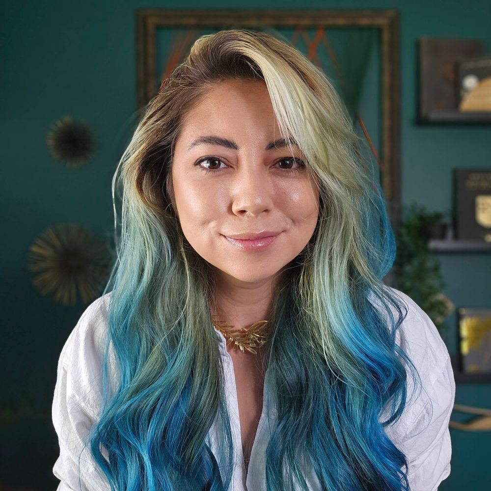 Caustic bleaches her hair and it fades to teal at the bottom 