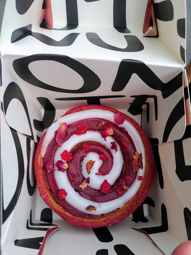 Raspberry Marzipan Swirl 
Raspberry and marzipan filling, fondant icing, raspberry jam, freeze dried raspberries and rose flakes