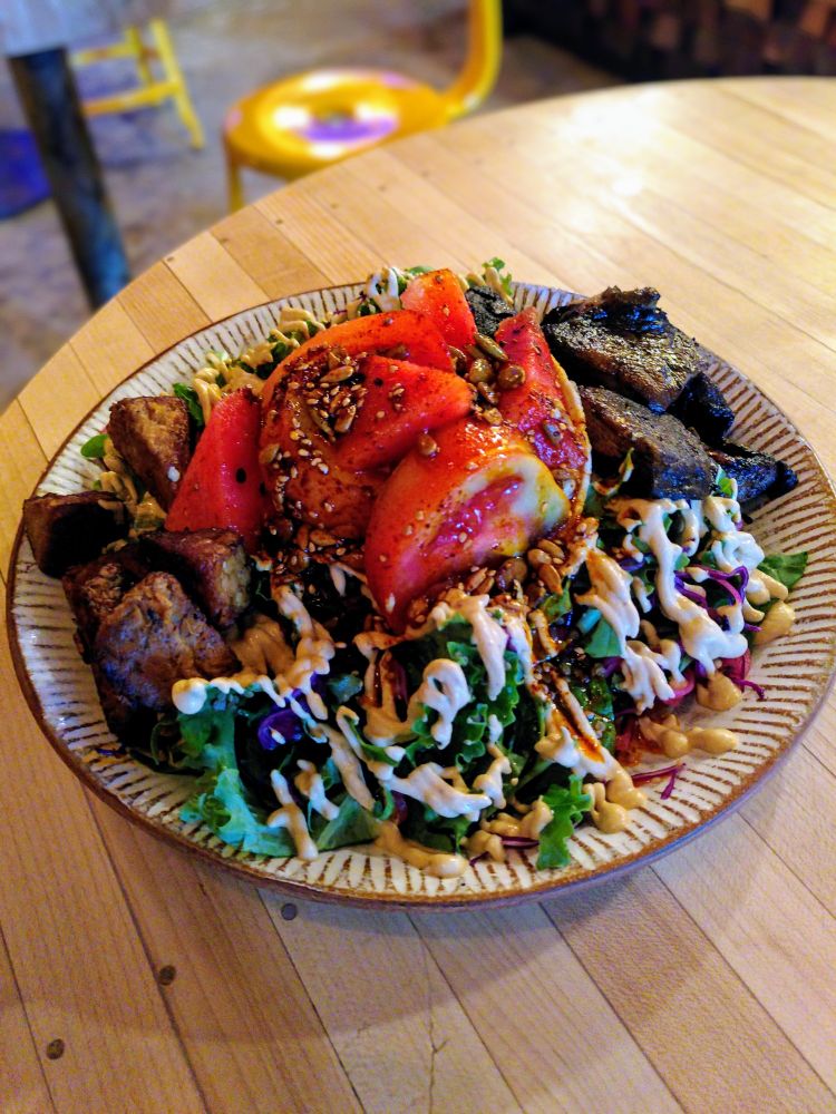 The Mexican Tostada
Pinto beans, quinoa, red cabbage, kale leaves, pickled onion, tostada top, hot pickle seasonal veg, tomato, Palm Greens chipotle crema, toasted seed guajillo oil - plus ginger tamari tempeh, roast portobello mushrooms and burnt habanero chile oil