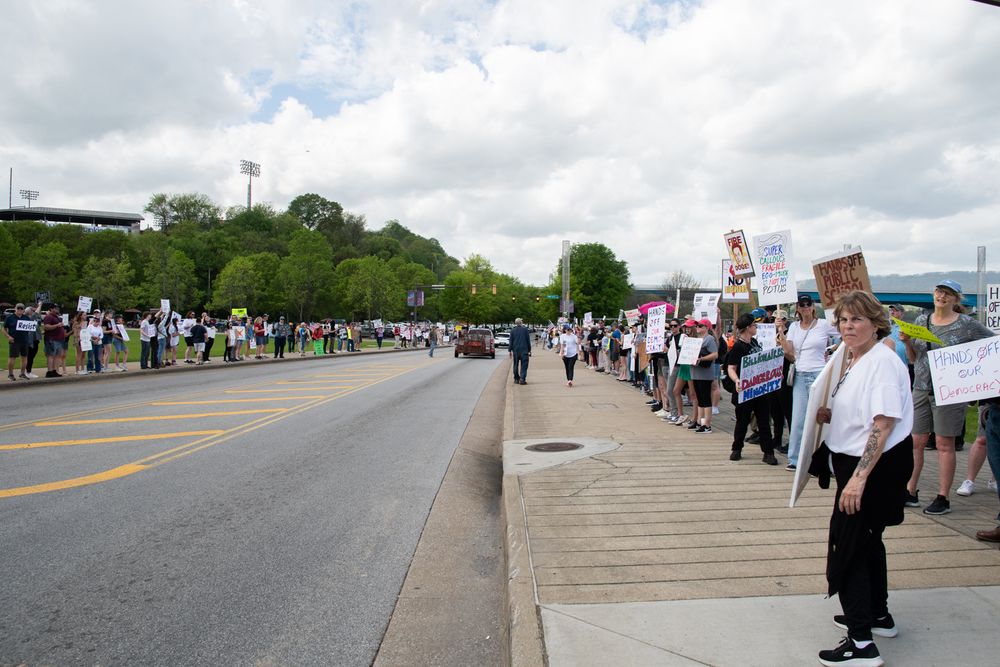 Protestors along  both sides of street.
