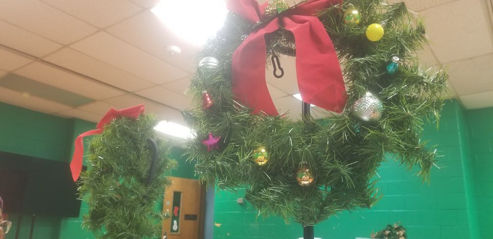 Photo of 2 decorated wreath covered in a bow and various holiday bells & ornaments.