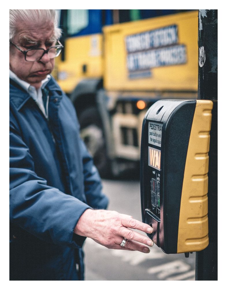 Man pressing the button at a pedestrian crossing. 