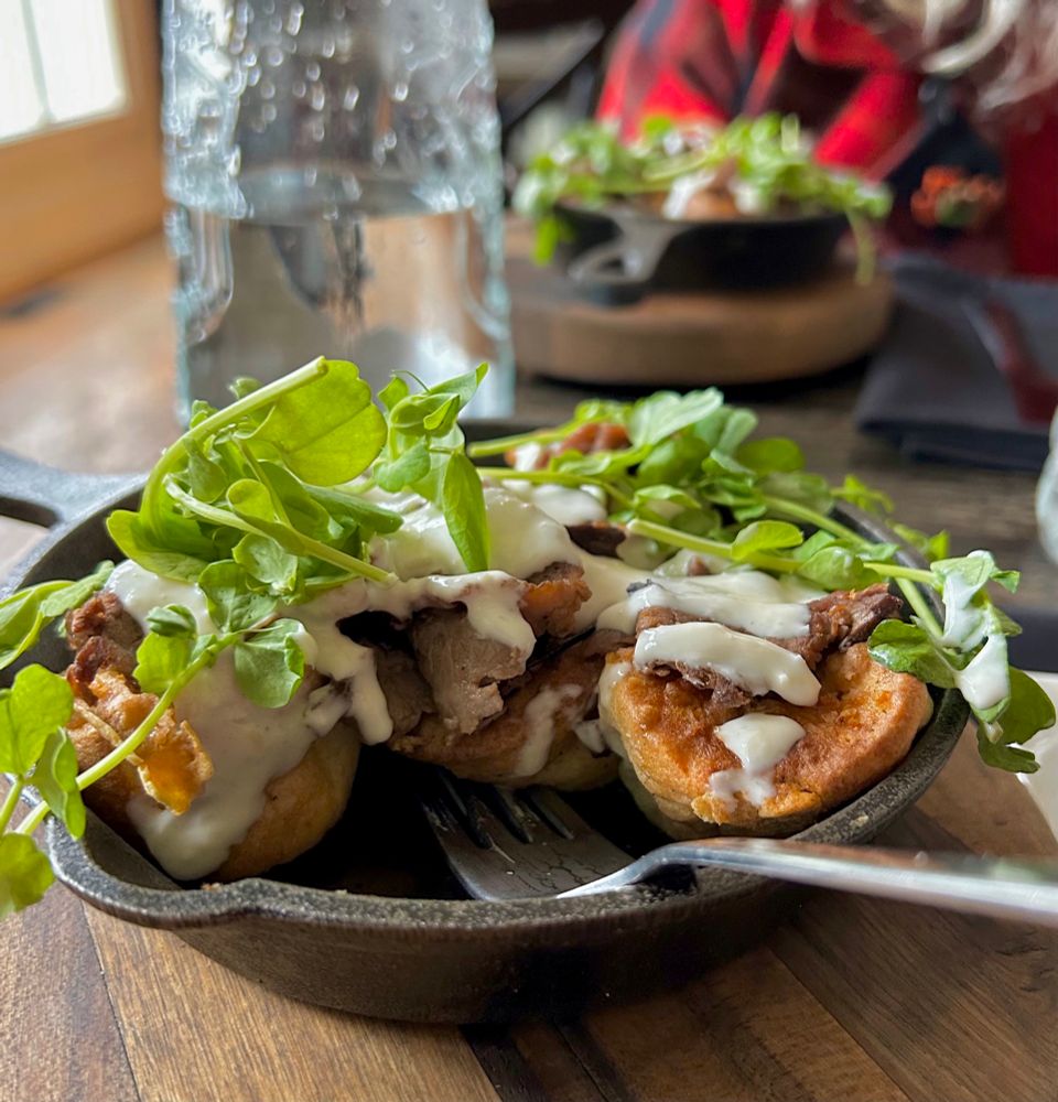 A delicious lunch, a cast iron skillet of mini Yorkshire puddings, stuffed with tender thin slices of roast beef and topped with horseradish aioli and pea shoots. 