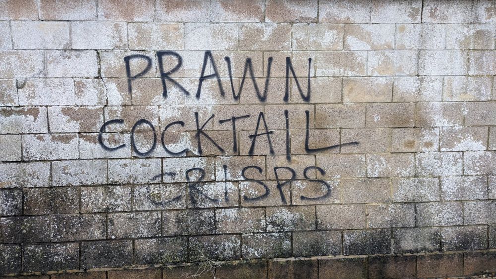 Rubbish graffiti: "PRAWN COCKTAIL CRISPS"