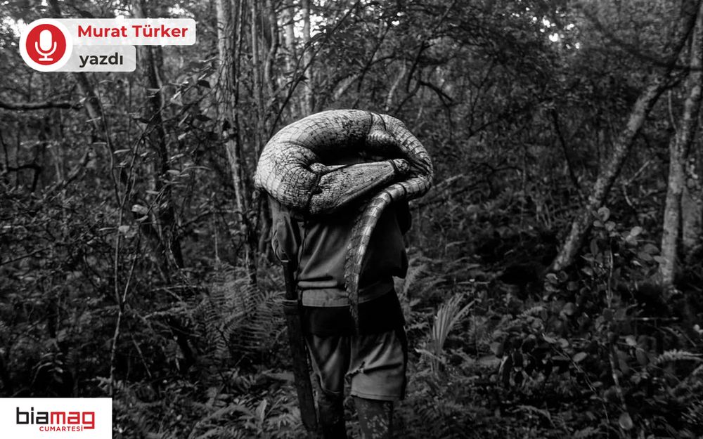 Görselde, siyah beyaz bir orman manzarasında, sırtında dev bir yılan taşıyan bir kişi yürürken görülüyor. Elinde büyük bir pala var. Sol üstte “Murat Türker yazdı”, sol altta “biamag cumartesi” logosu yer alıyor. Görsel, vahşi doğa ve insan ilişkisini çarpıcı biçimde yansıtıyor.