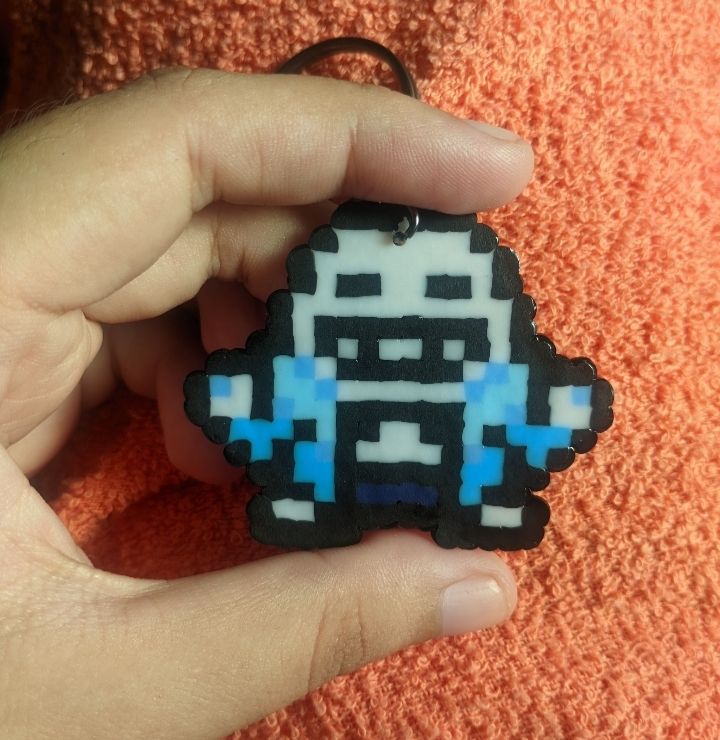 On the left side of the picture is my hand, holding the perler keychain for size comparison. It's very small, I hold it with my index finger and thumb