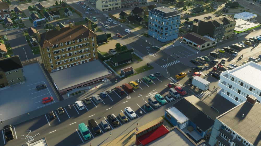 A screenshot of my Cities: Skylines 2 city Trinity Gate showing a street corner surrounded by some medium density and some low density buildings.
