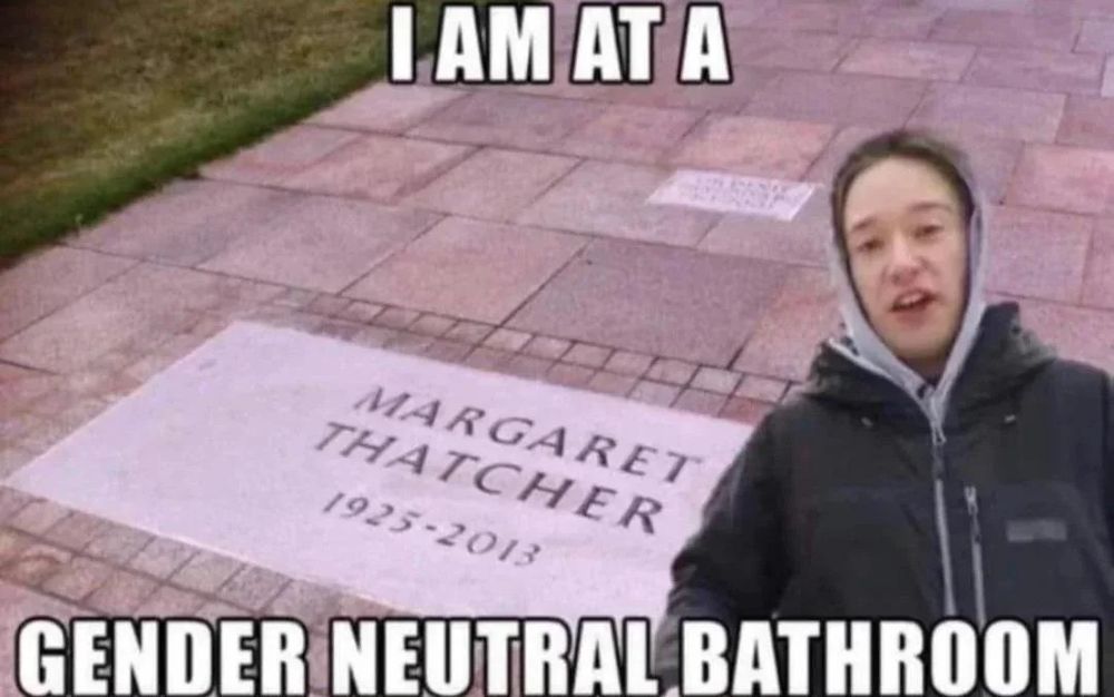 Tom Scott is photomontaged in front of the gravesite of Margret Thatcher. The captions say “I AM AT A GENDER NEUTRAL BATHROOM.“