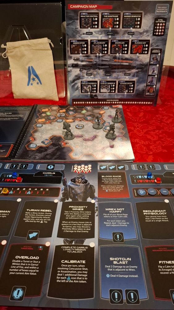 A board game on display. A hex map, with tokens and miniatures of characters from Mass Effect are on a table.