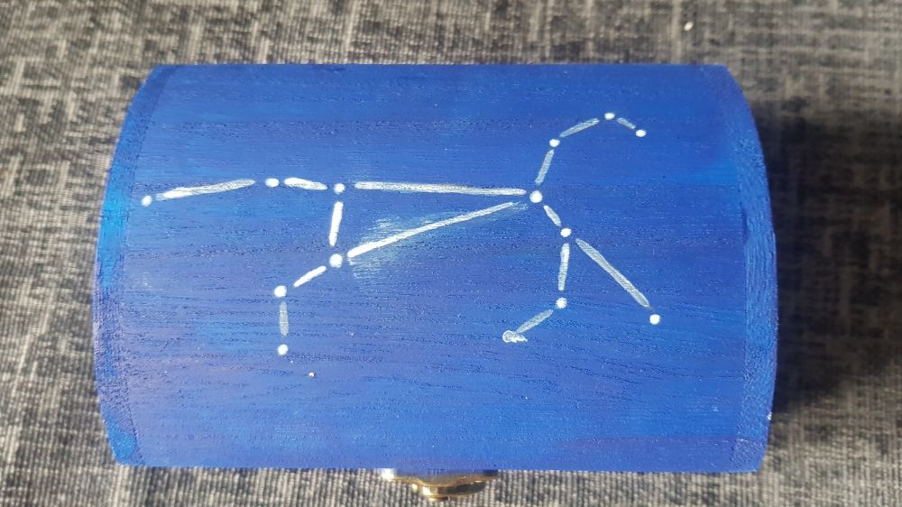 The top of a chest painted blue, with the constellation of a horse in white.