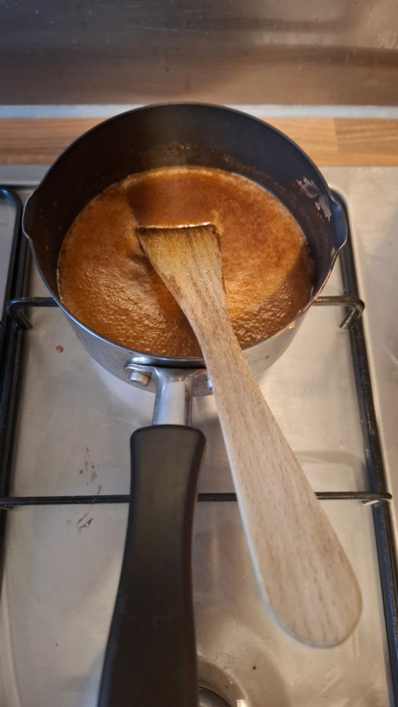 A saucepan with a wood spatula, with hot chocolate inside