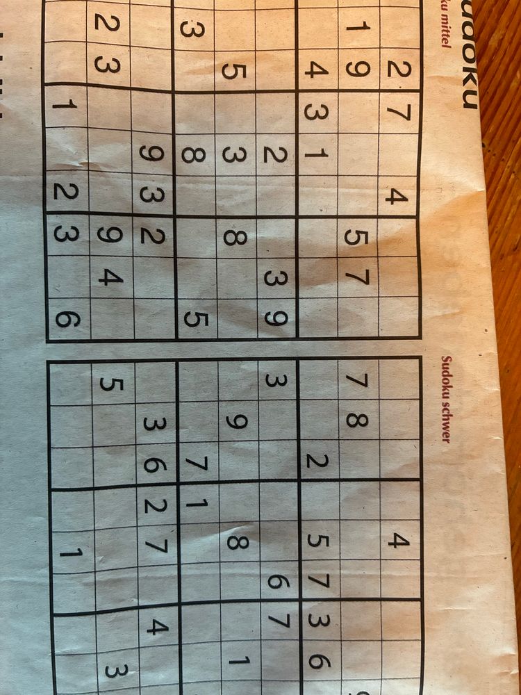 Man sieht eine Seite Käseblättchen fotografiert. Darauf zwei Sudokus. In zwei unterschiedlichen Schrifttypen.