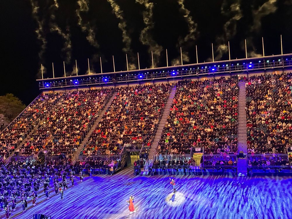 Abschluss mit Erzähler und Piper. Im Hintergrund Publikum und Rauchwolken von den Kanonen. 