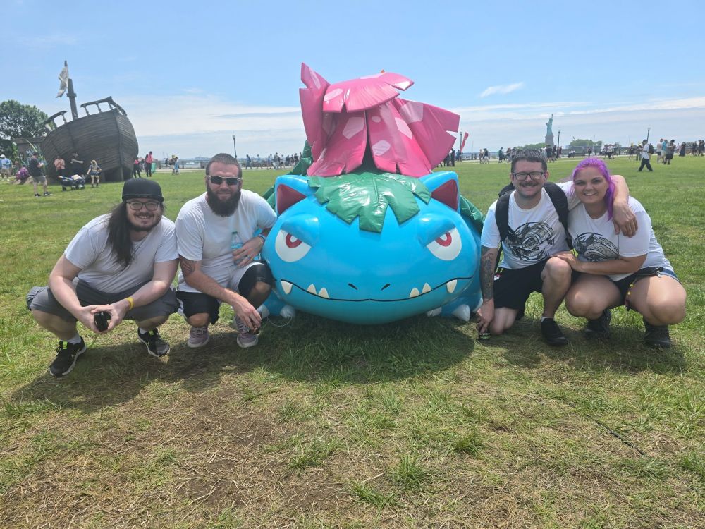 A picture in a field depicting, from left to right, Falling_Tacos, Pokermarine24, Venusaur, Anariodin, and Ally. There is also a pirate ship in the background and a Statue of Liberty.