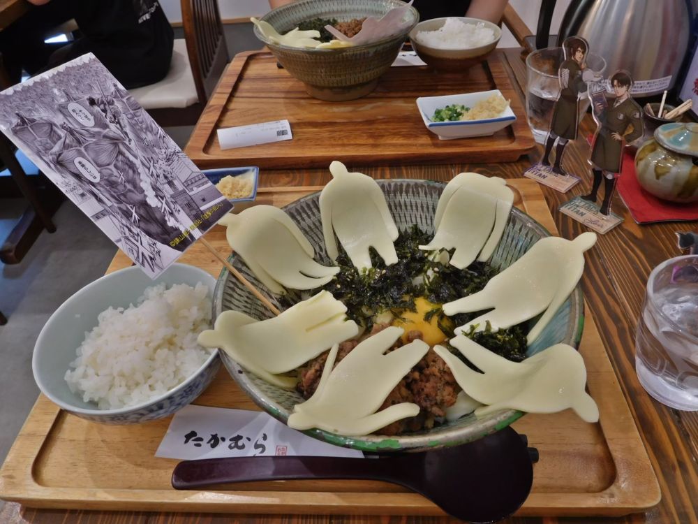 大分県日田市で食べられる「進撃のバターチーズうどん ザ・地ならし」。ハンジさんが「…やっぱり巨人って素晴らしいな」と言っている名シーンのカードが刺さっています。