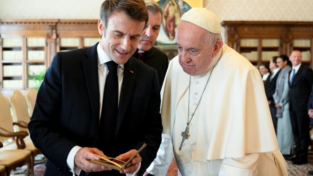 Macron lit quelque-chose avec le Pape.