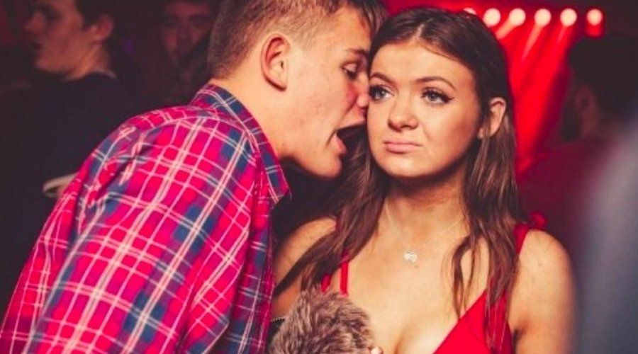 Jeune homme qui parle beaucoup trop près à une jeune fille. Celle-ci semble désespérée d'être obligée de l'écouter.