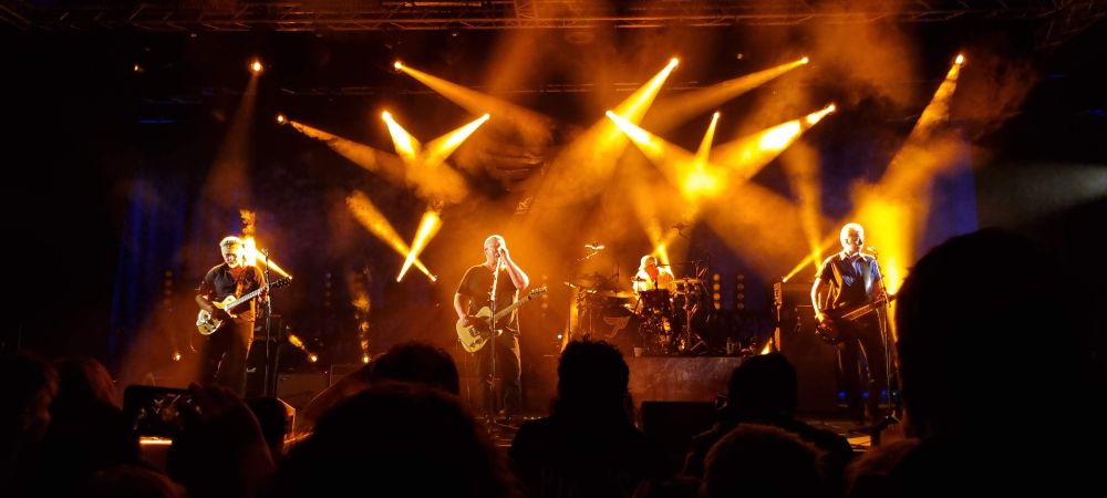 The band Pixies on stage, with orange lights