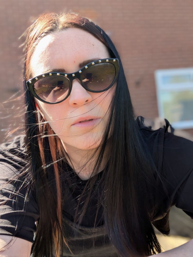 Summer goth wearing sunglasses outside house (dying in the heat)
