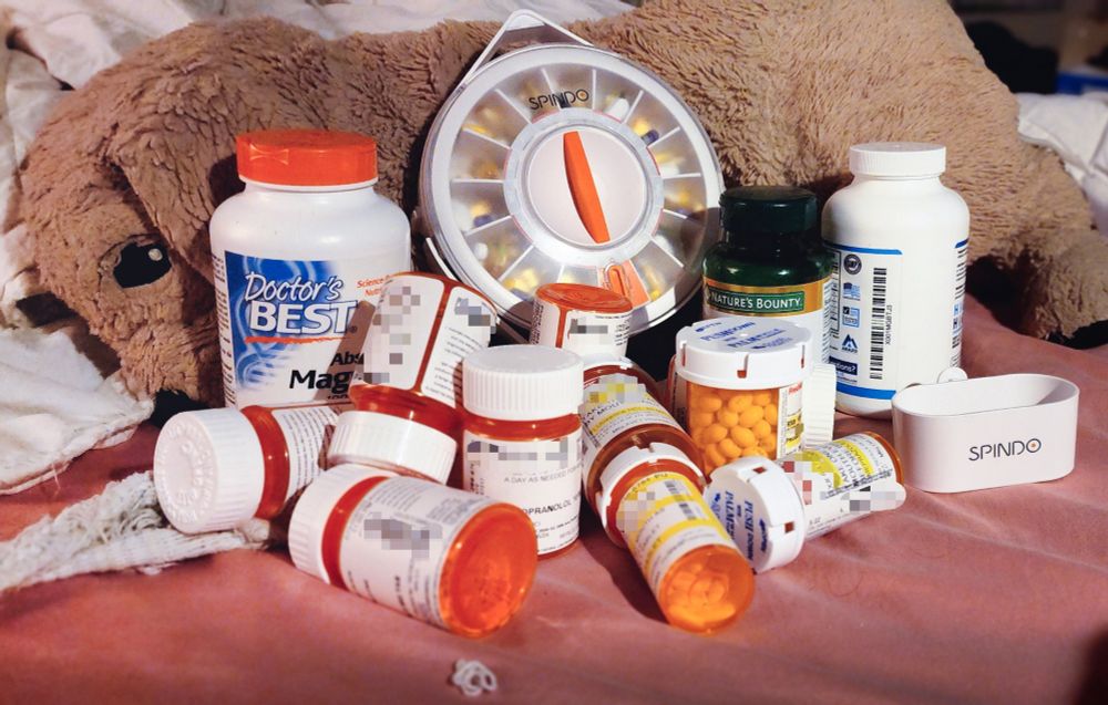 a pile of prescription bottles stacked on a stuffed dog