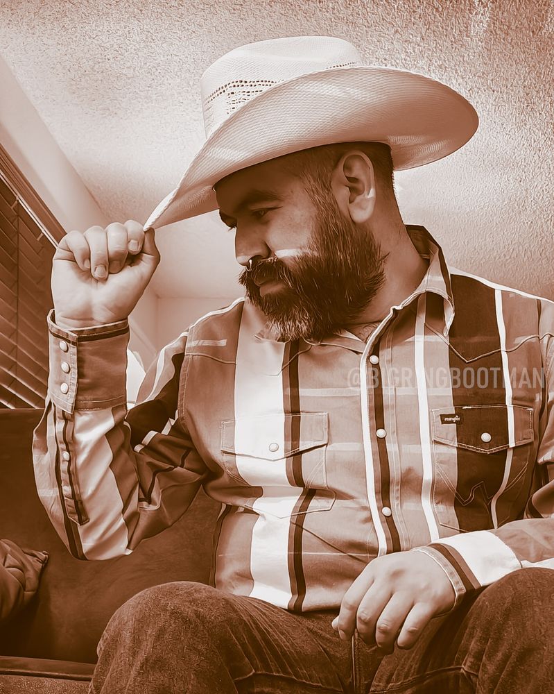 sepia picture of myself in western wear holding the tip of my cowboy hat