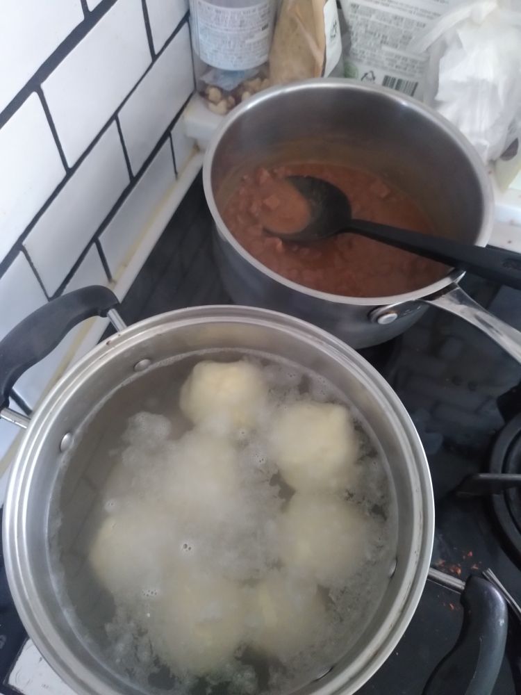Klöße garen im Topf, dahinter ein Aldi-Dosengulasch, das mir mein Vater mal mit horrendem Porto geschickt hat, hab mich aber gefreut.