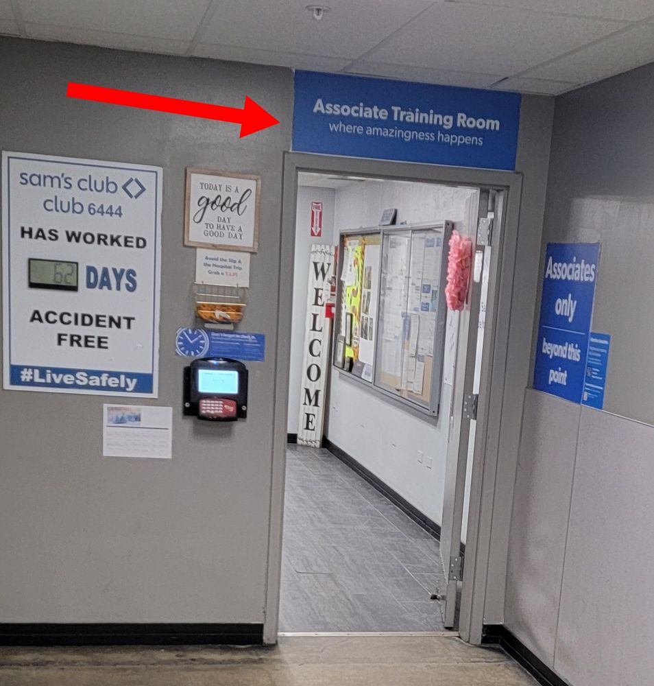 The "Associate Training Room" door at Sam's Club, over which a sign says, "where amazingness happens." Another sign says that "today is a good day to have a good day." An LCD on a sign to the left of that counts 62 days accident-free at Sam's Club 6444.