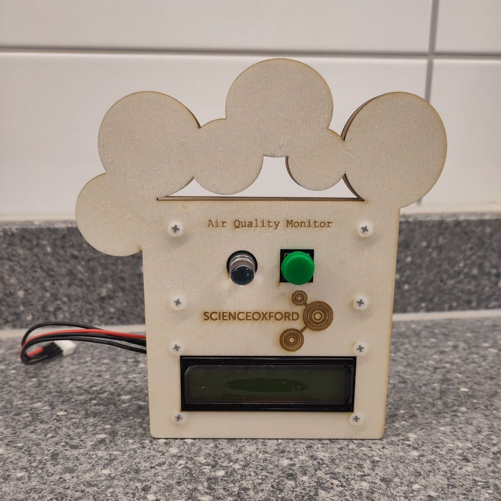 Laser cut outline shaped like a cartoon face, with an LED, pushbutton and LCD screen attached