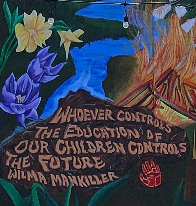 Colorful floral mural including the quote "Whoever controls the education of our children controls the future" by Wilma Mankiller.
