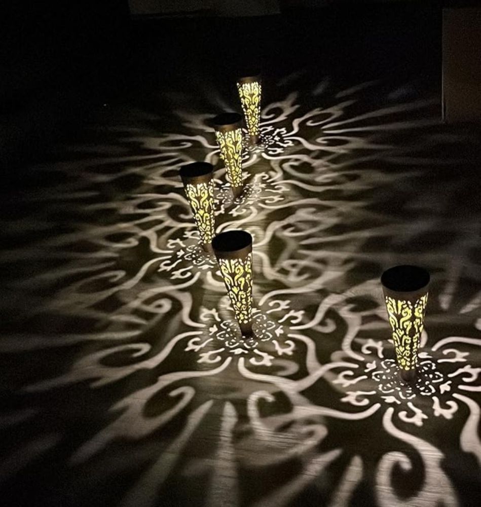 The image shows 5 outdoor lights casting shadows on the pavement they've been installed next to. This is a (free) stock photo.