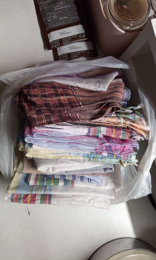 A stock of the handkerchiefs in a small grocery bag. The stripes are colourful and differ a lot.